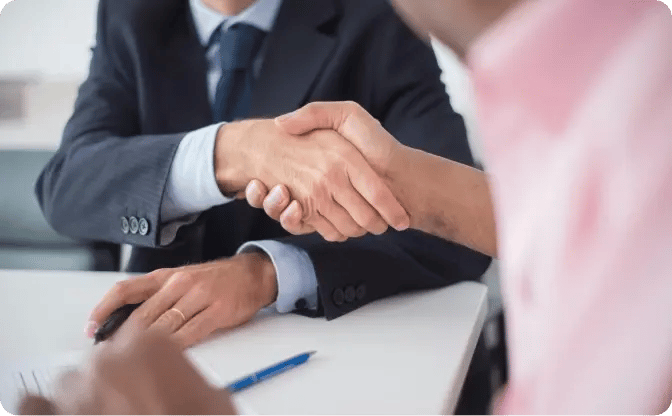 Two people shaking hands, representing trusted compliance support.